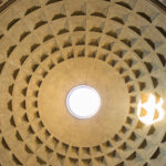 Kuppel von unten: im Zentrum ein Lichtloch, durch das seitlich ein Sonnenfleck ins Kuppelinnere geworfen wird. Die Kuppel ist rundum durch über hundert quadratische Einbuchtungen gegliedert.
