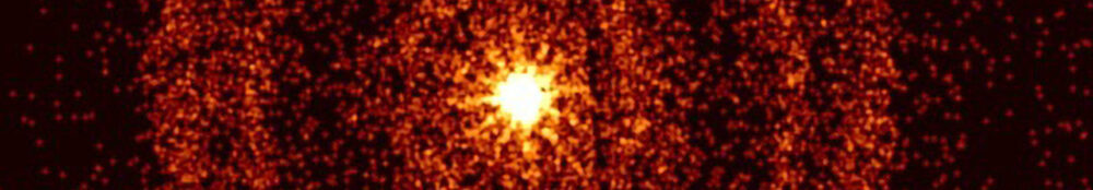 Vor einem schwarzen Hintergrund ist im Zentrum ein orange-gelblicher Kreis zu sehen, umgeben von mehreren konzentrischen Ringen, die ebenfalls orange-gelblich eingefärbt sind und deren Dichte nach außen hin abnimmt.