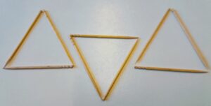 Photo of nine toothpicks arranged into three separate triangles. The left and right triangles point up, and the centre one, whose top edge is about halfway down the others, points down