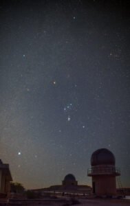 Orion mit Sternen in der Umgebung über einer Teleskopkuppel